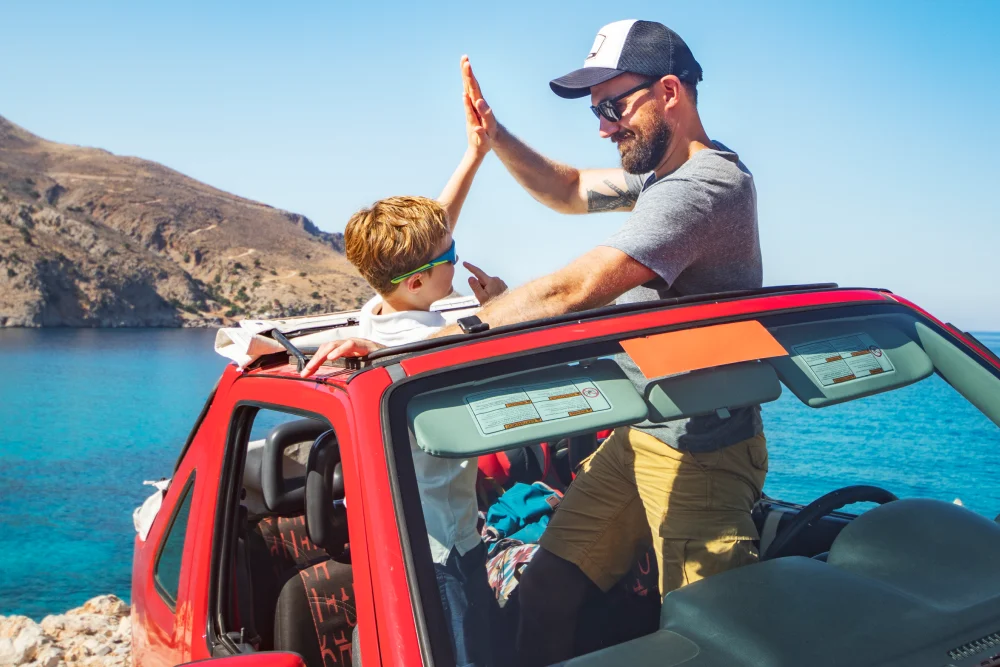 Bild Vater & Sohn rotes Auto Urlaub